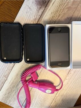 Apple Black iPhone with Pink Coiled Car Charger and Two Black Cases